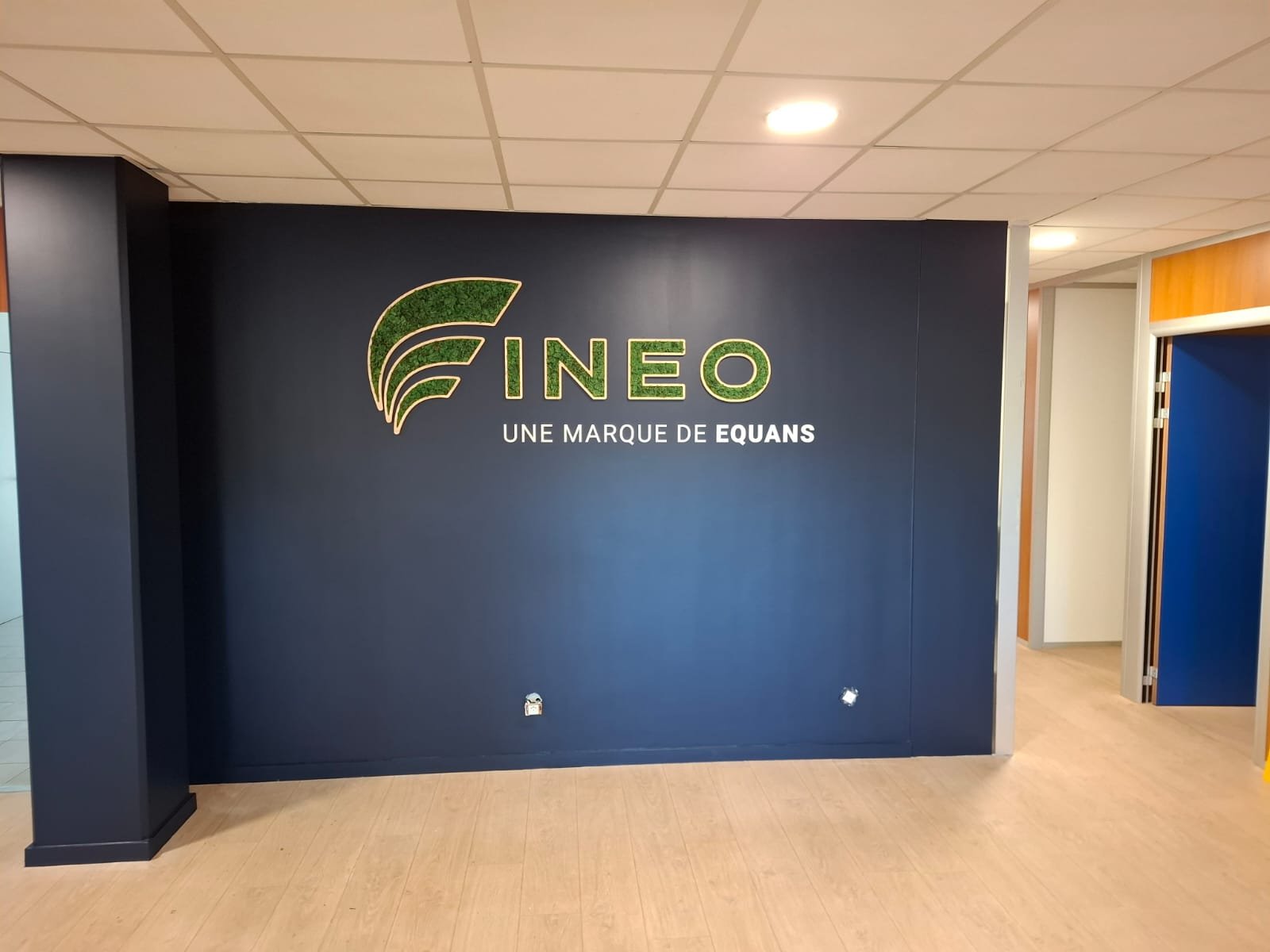 Logo végétal personnalisé réalisé pour INEO avec structure bois et lichen stabilisé vert